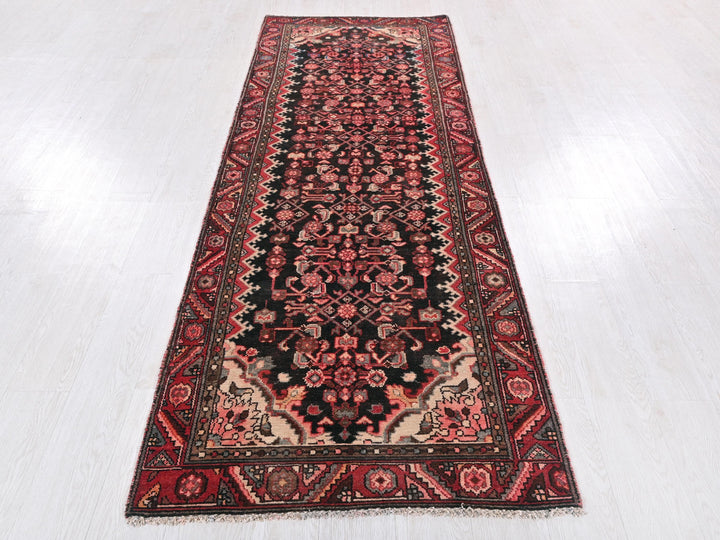 a red and black rug on a white floor