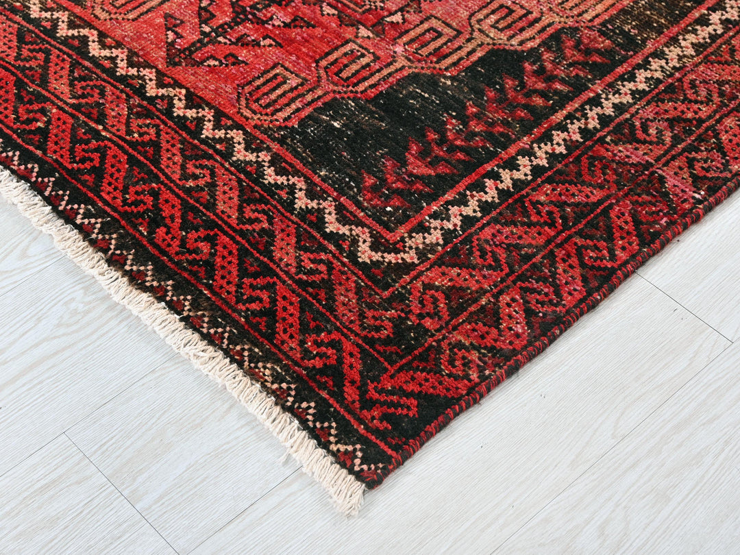 a red and black oriental rug on a white floor