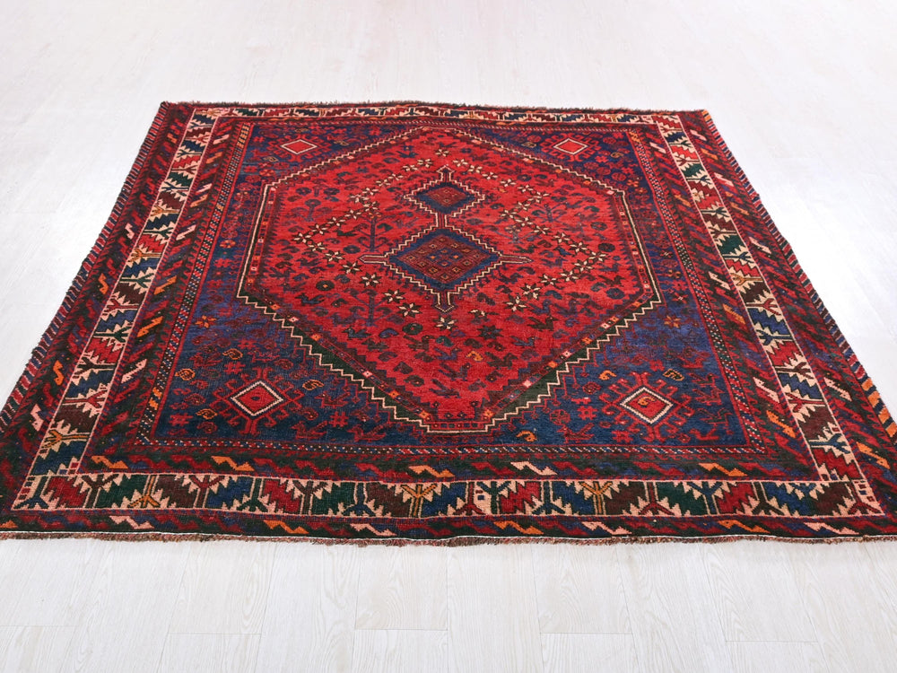 a red and blue rug on a white floor