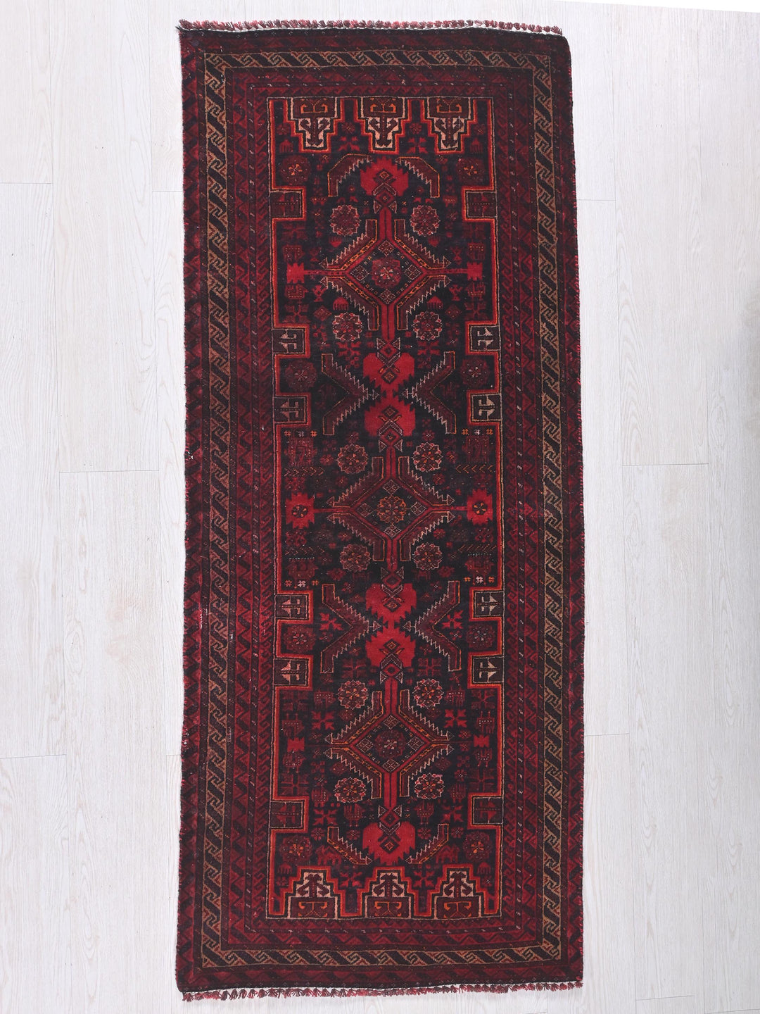a red rug hanging on a white wall