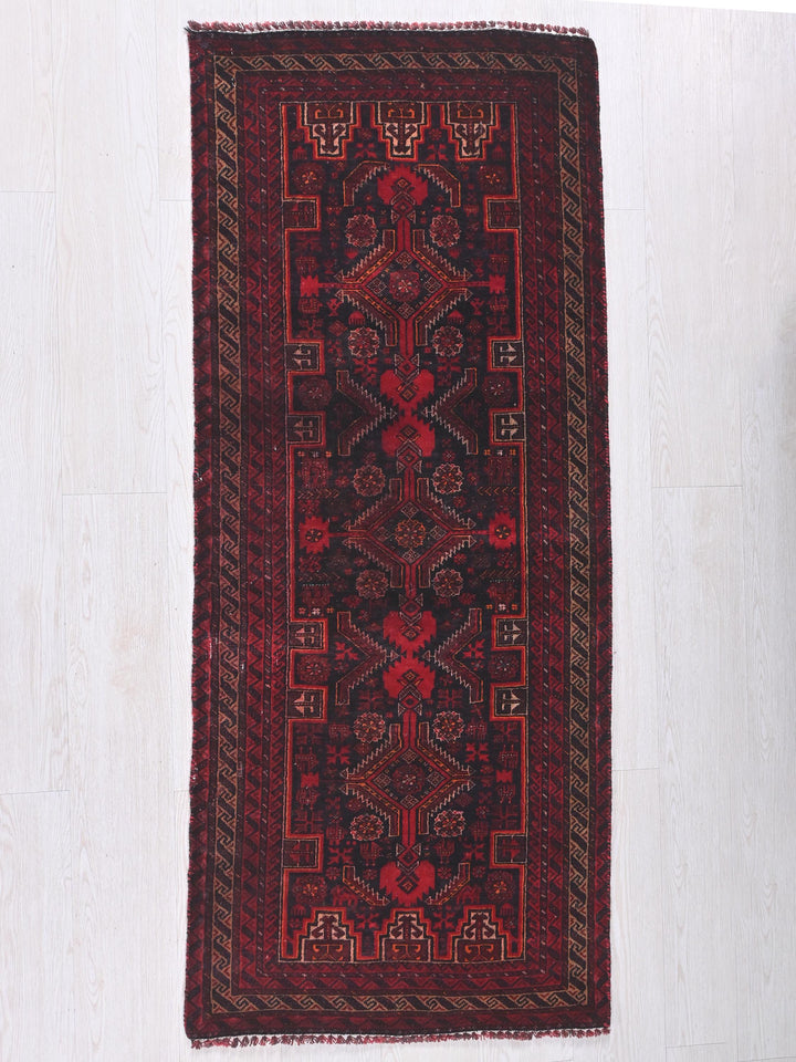 a red rug hanging on a white wall