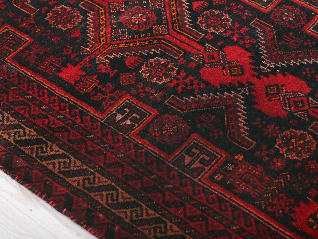 a close up of a red and black oriental rug