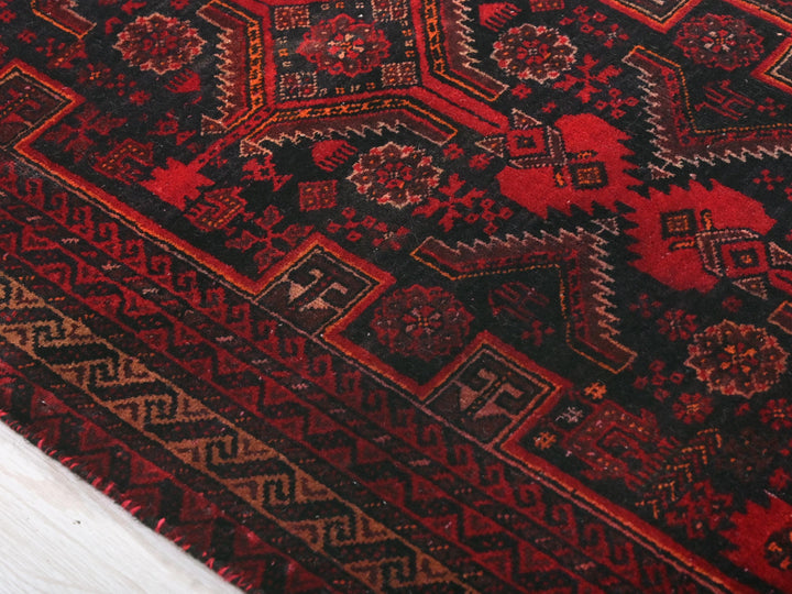a close up of a red and black oriental rug