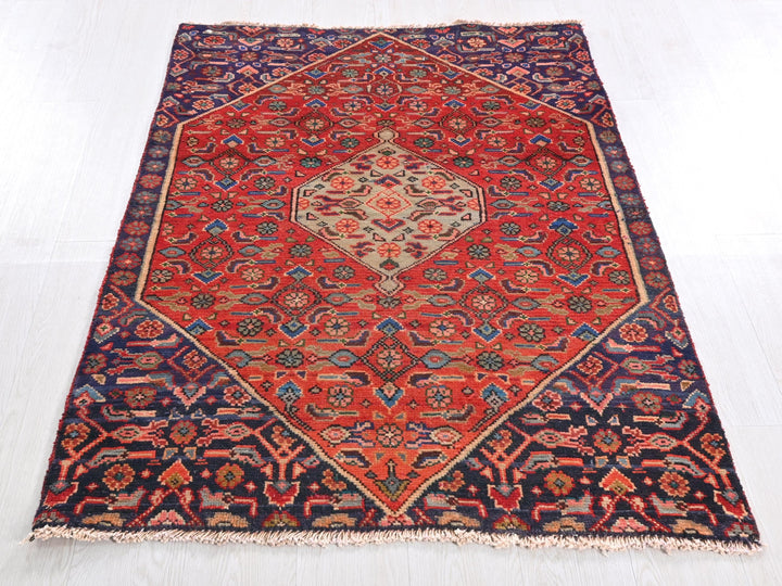 a red and blue oriental rug on a white floor