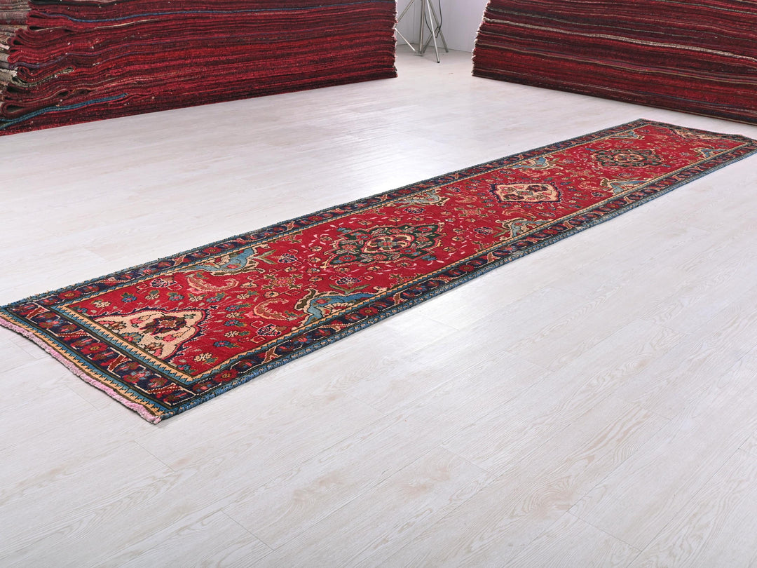 a pile of red rugs sitting on top of a white floor
