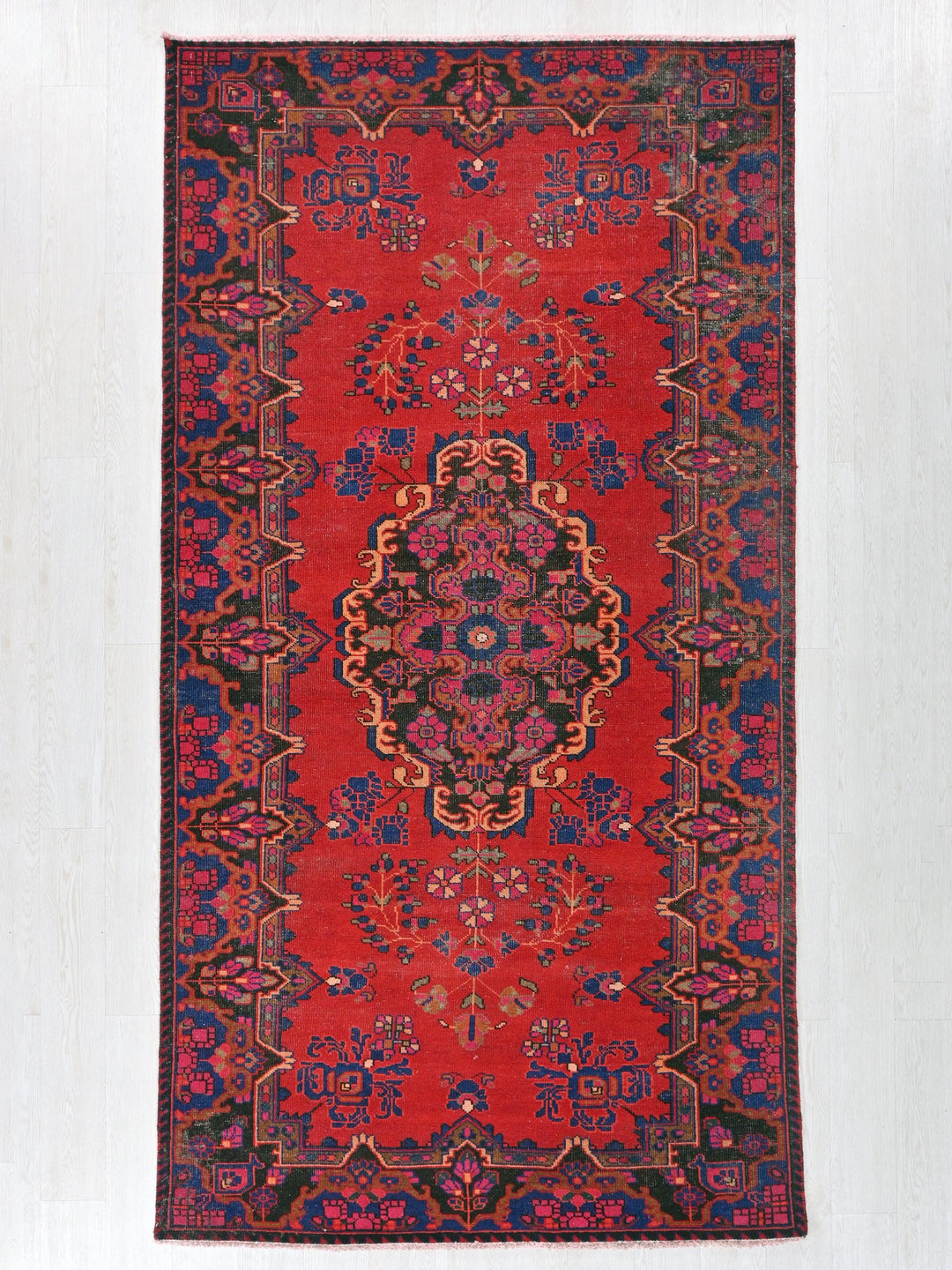 a red rug with a floral design on it