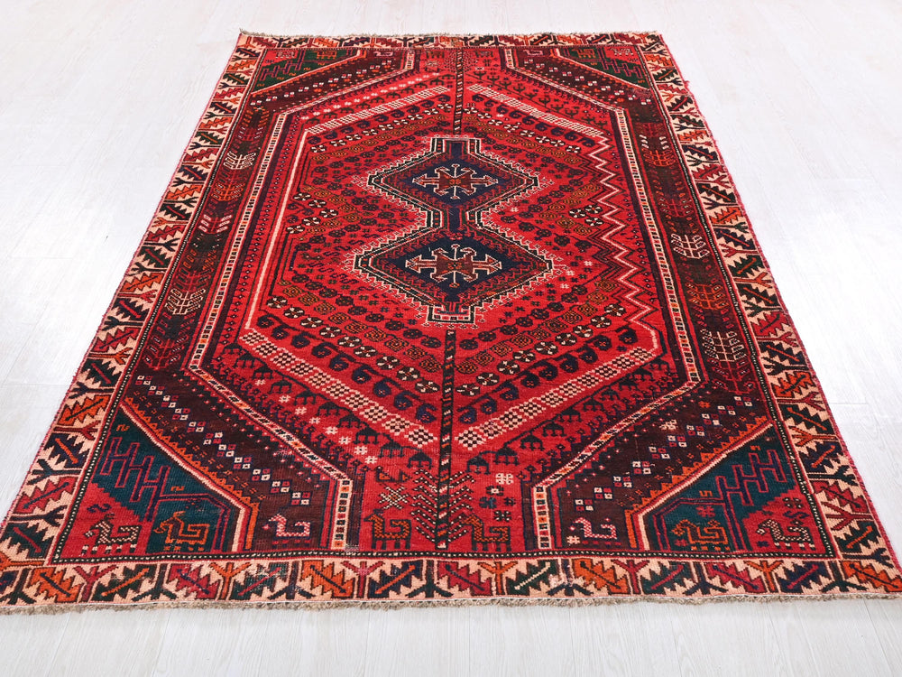 a red rug with a diamond shaped design on it