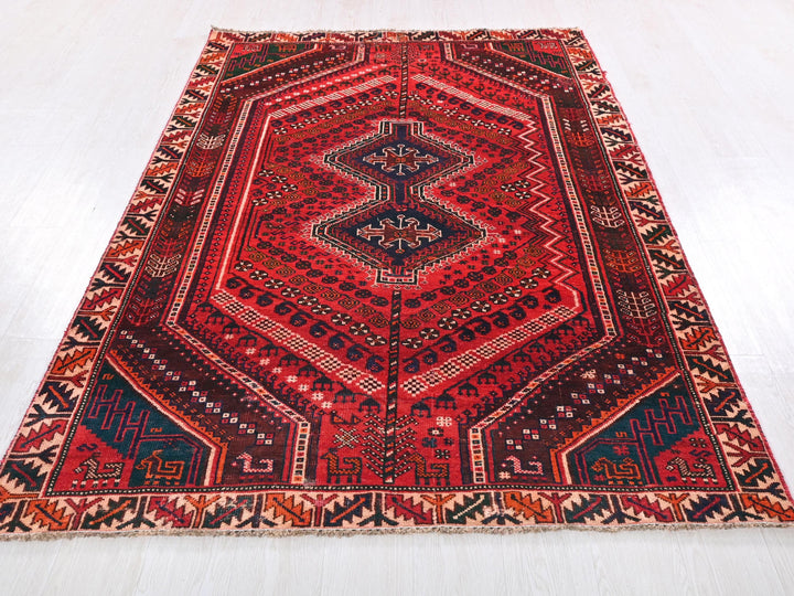 a red rug with a diamond shaped design on it