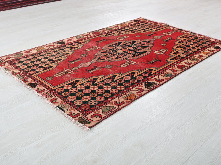 a red and black rug on a white floor