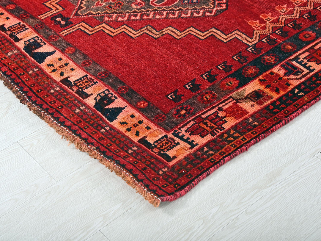 a close up of a red rug on a white floor
