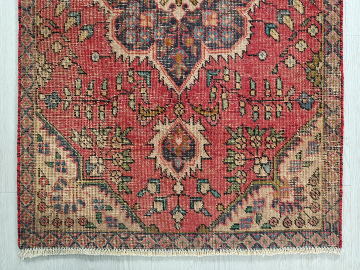 a red rug with a floral design on it