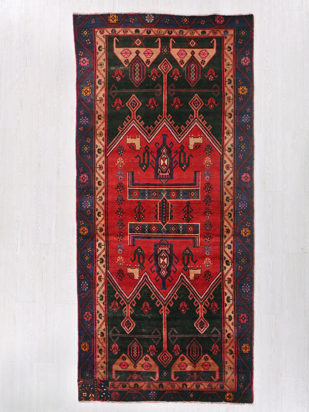 a red and black rug hanging on a wall