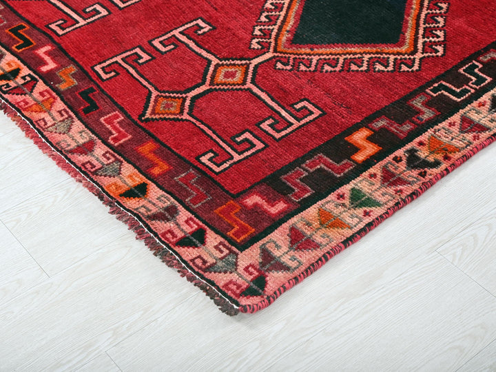 a red rug on the floor with a black square in the middle