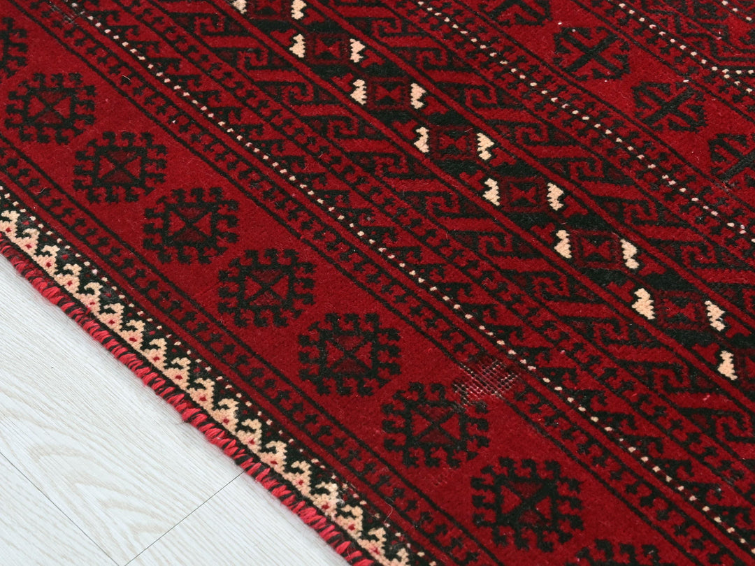 a close up of a red rug on a white floor