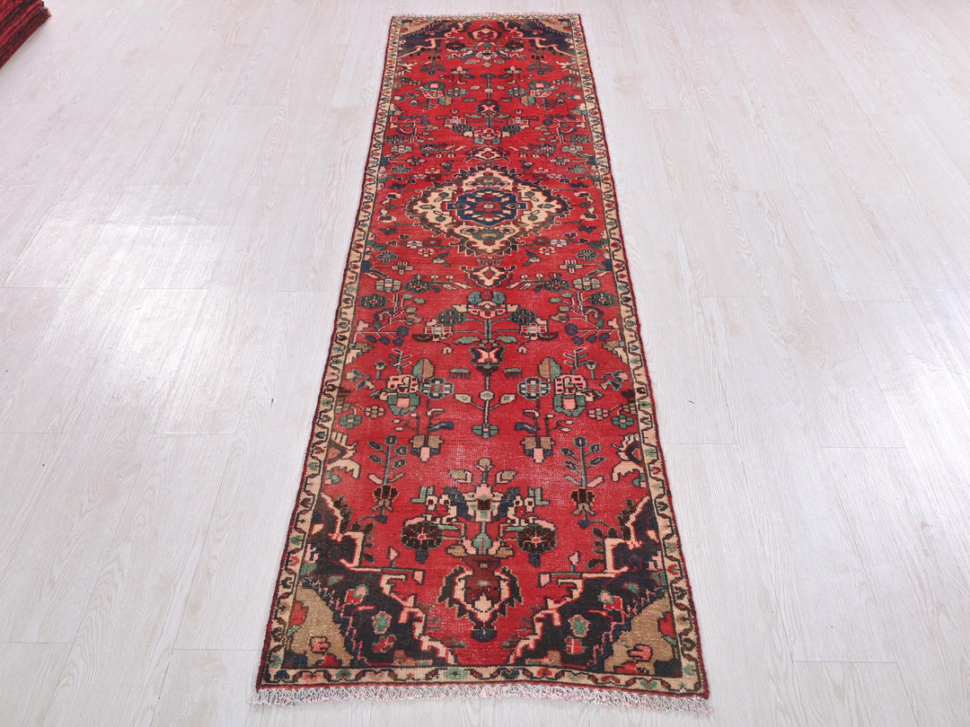a long red rug on a white floor