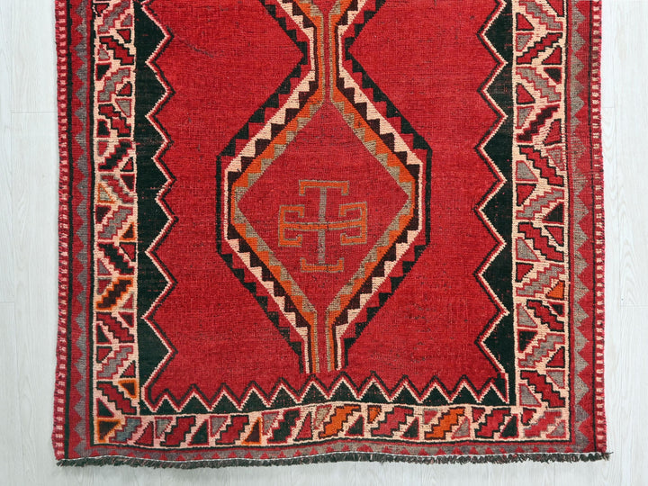a red rug with a design on it