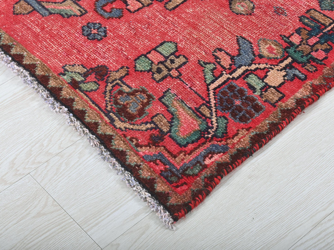 a red rug on a white wooden floor