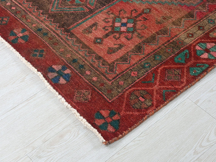 a red oriental rug on a white wooden floor