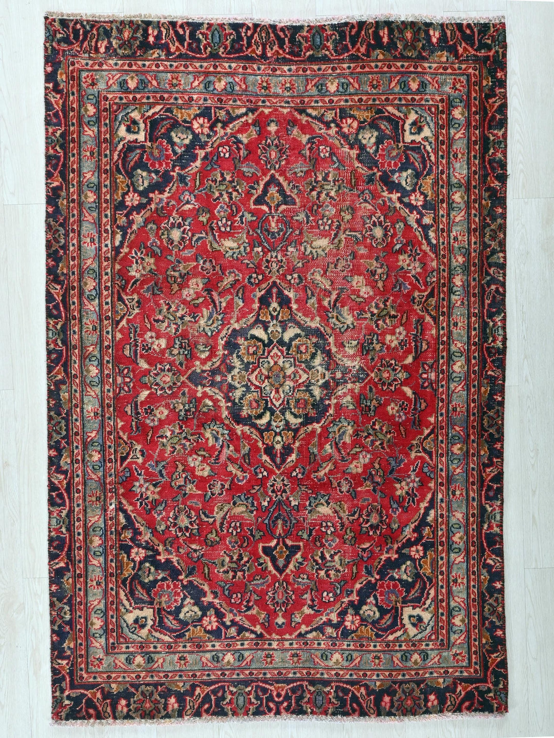a red and blue rug on a white floor