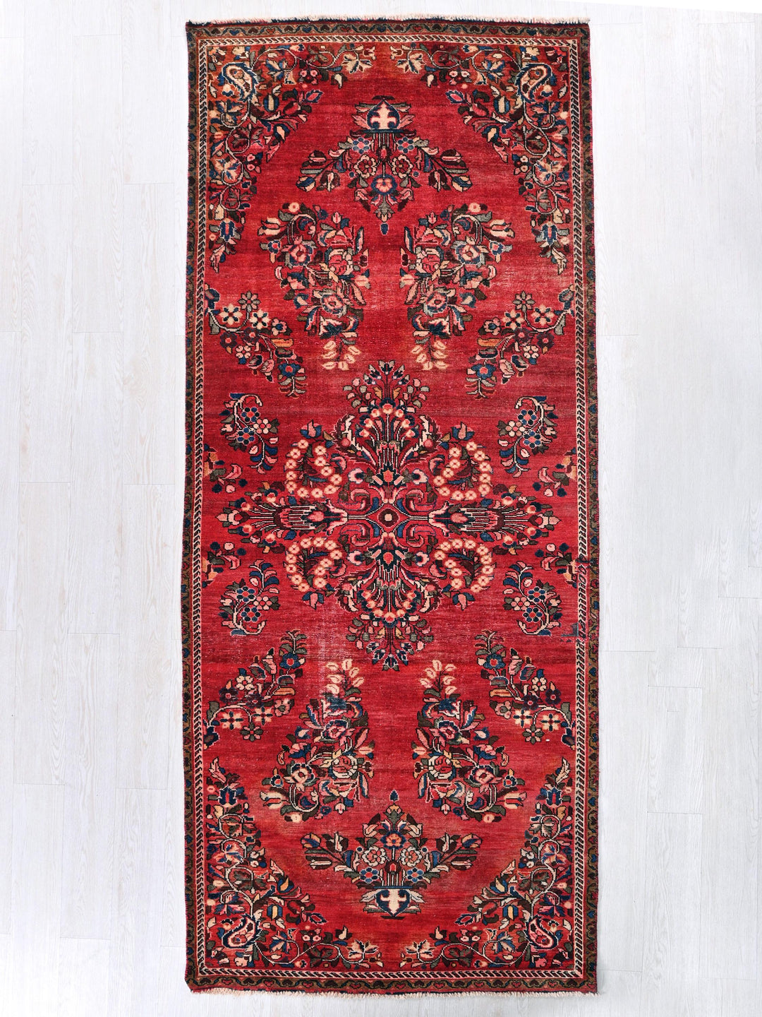 a red rug with a floral design on it