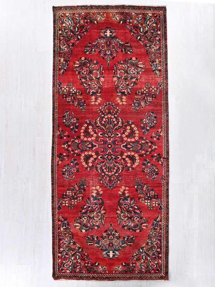 a red rug with a floral design on it