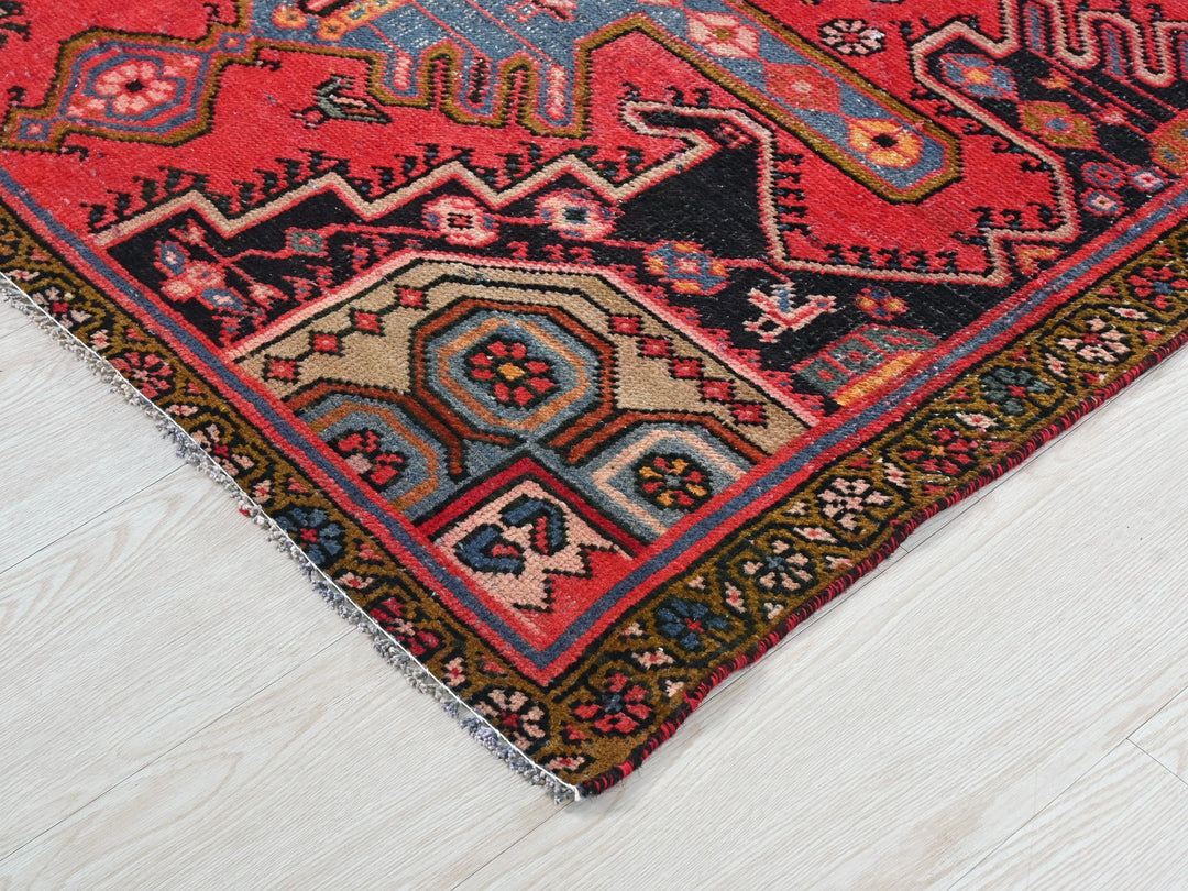 a red oriental rug on a white wooden floor