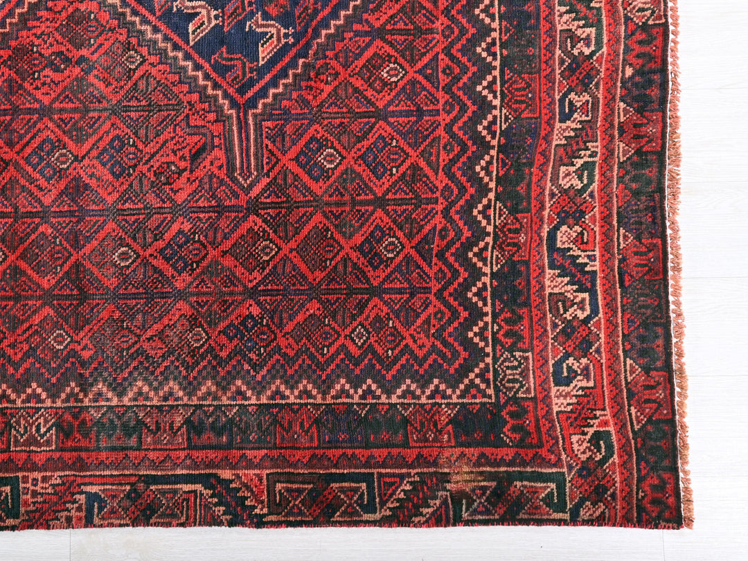 a red and blue rug with a diamond pattern