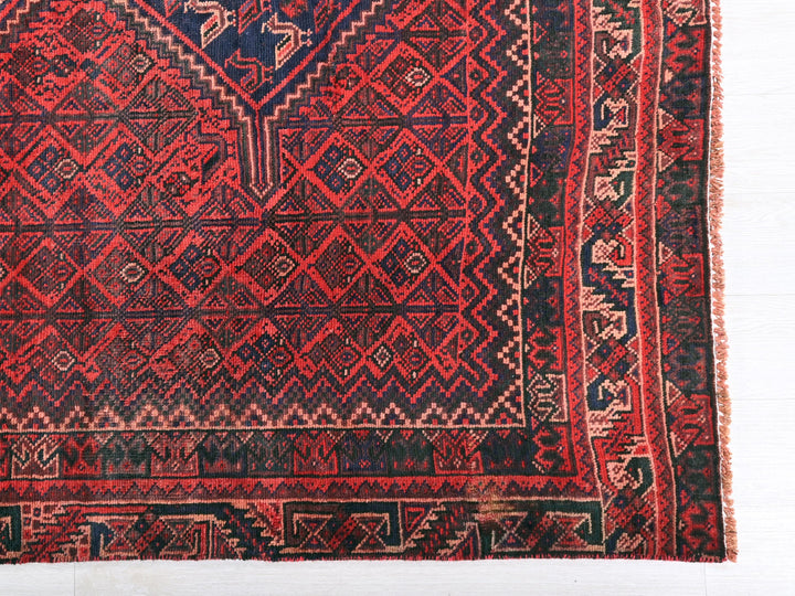 a red and blue rug with a diamond pattern