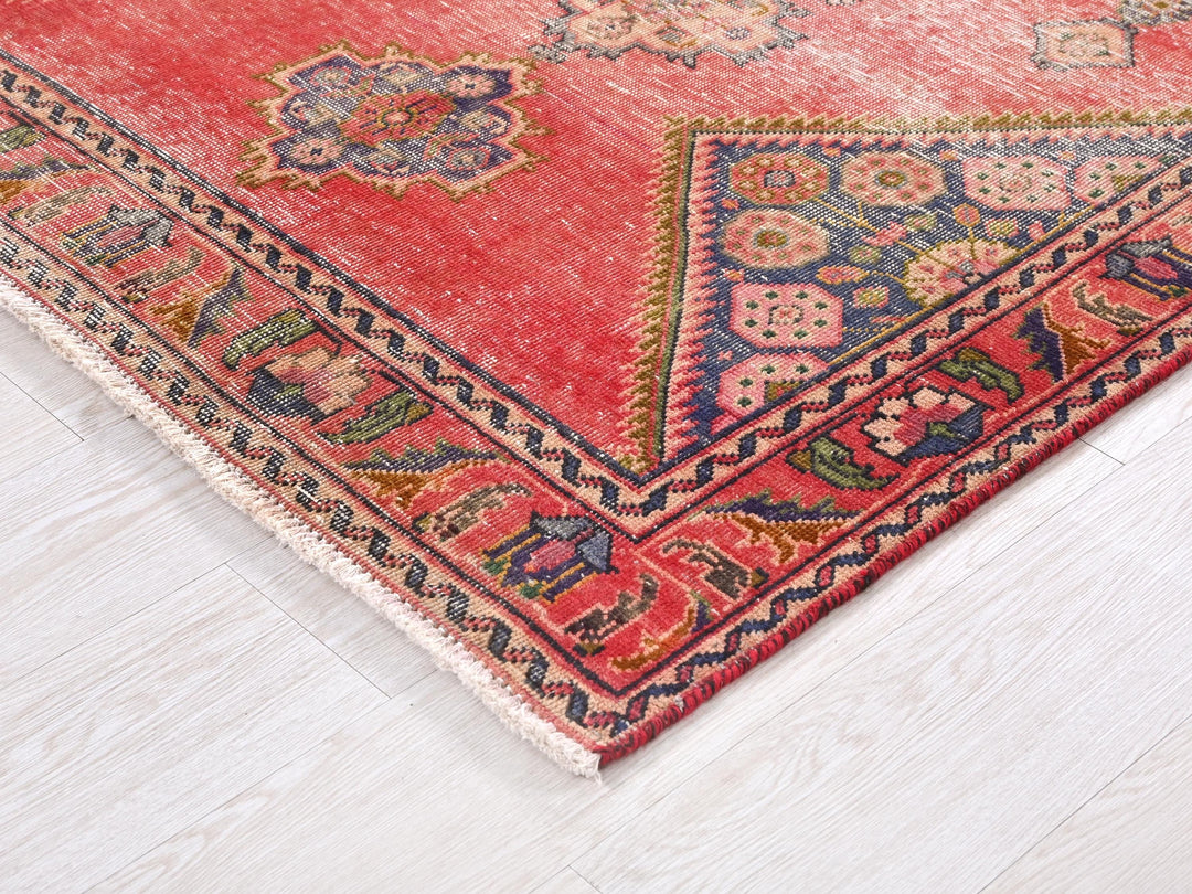 a red oriental rug with a diamond shaped design