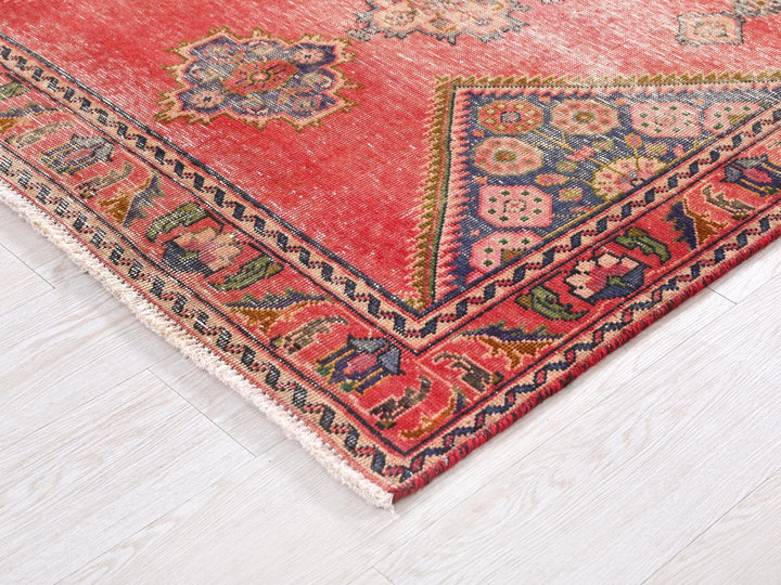 a red oriental rug with a diamond shaped design