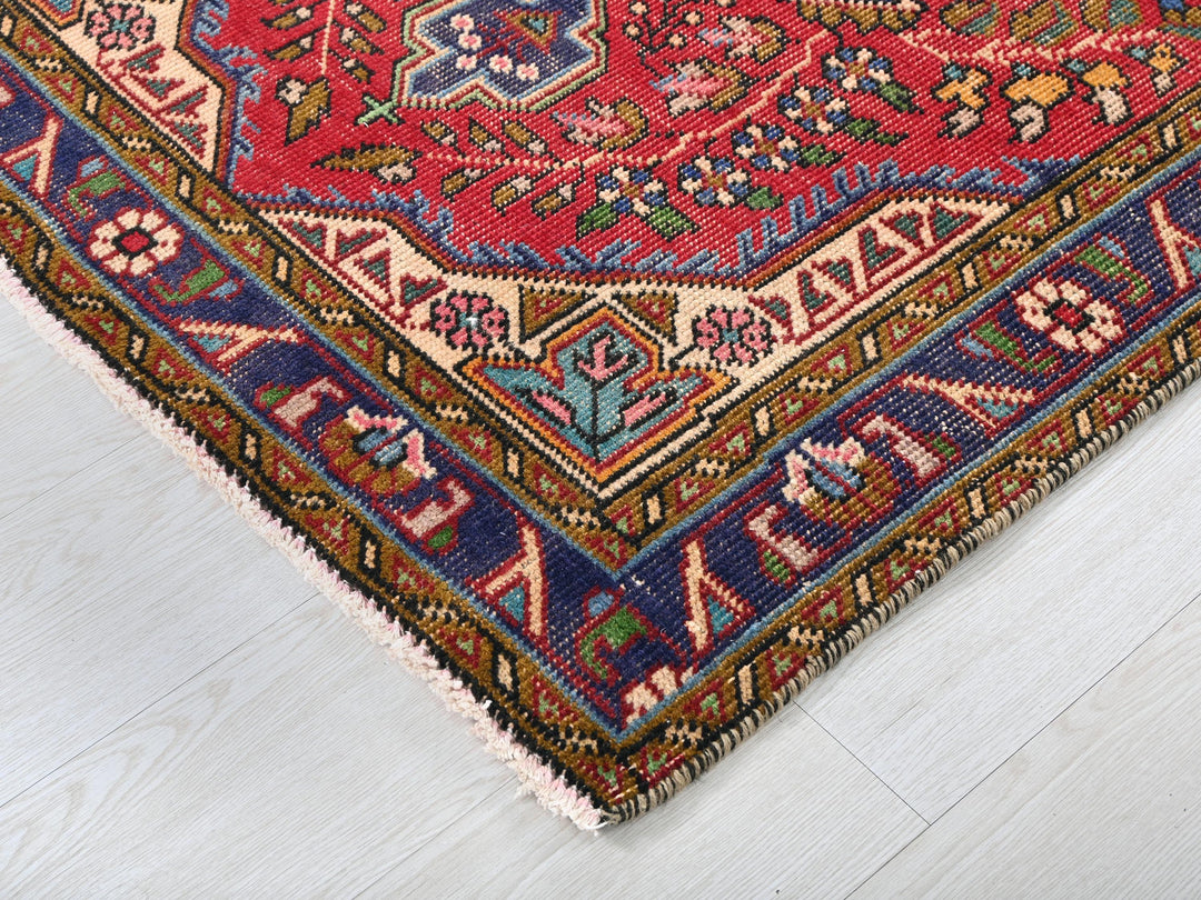 a red rug with a blue border on a white floor