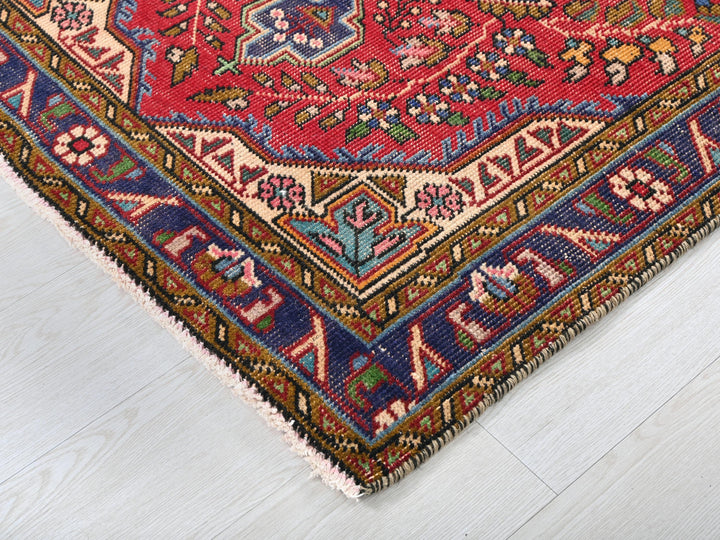 a red rug with a blue border on a white floor