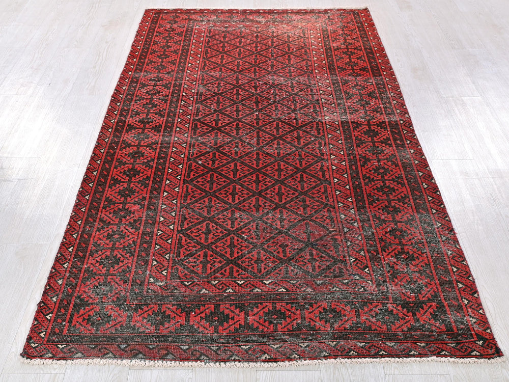 a red and black rug on a white floor