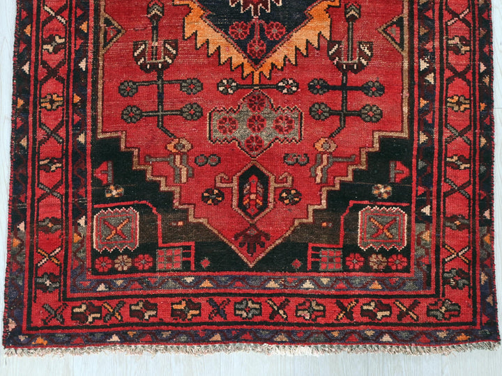 a red and black rug with a design on it