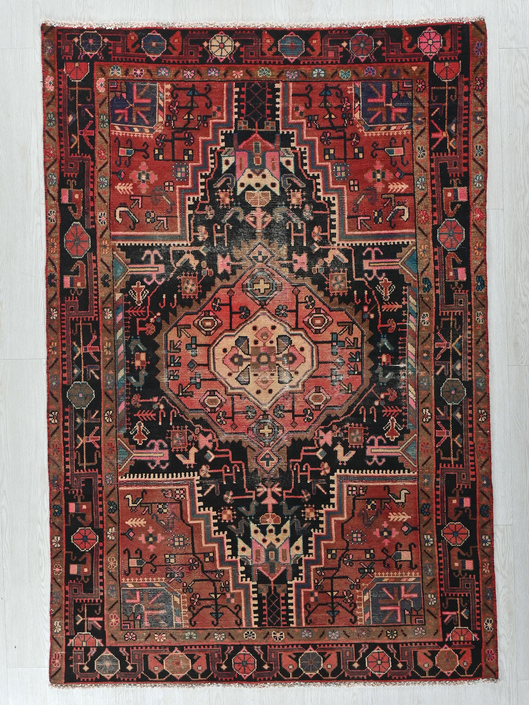 a red and black oriental rug hanging on a wall