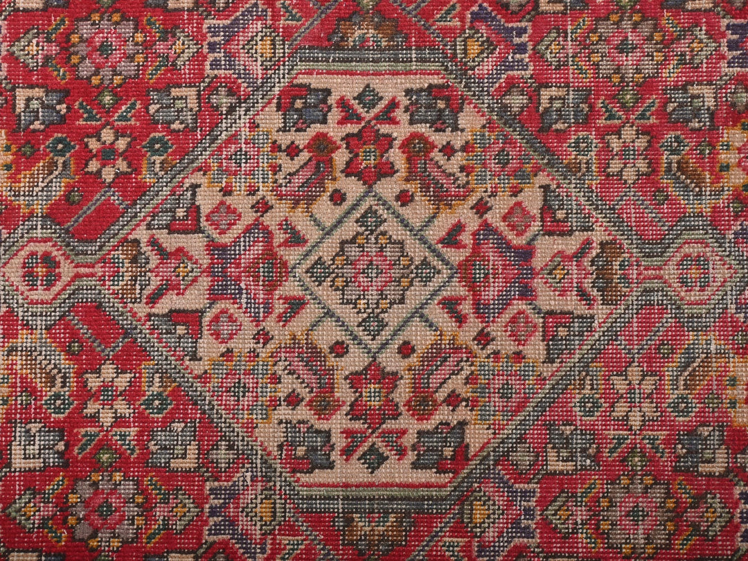a red and blue rug with a pattern on it