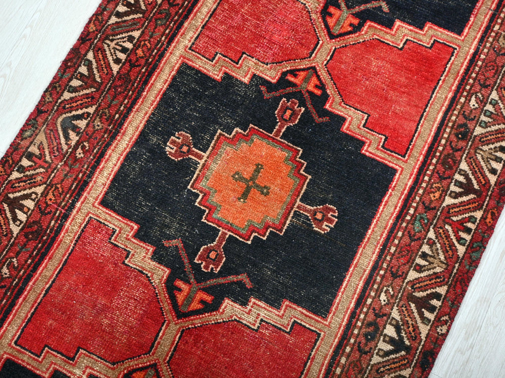 a red and black rug with a cross on it