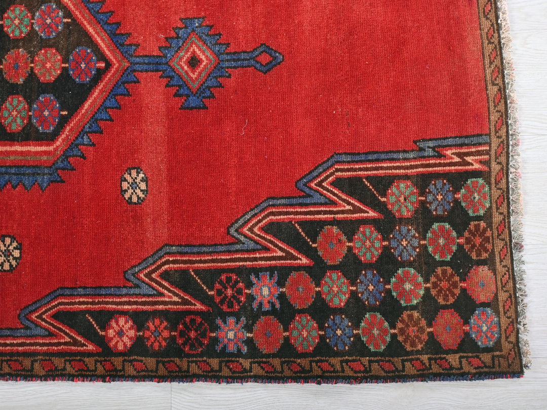a red rug with a design on it