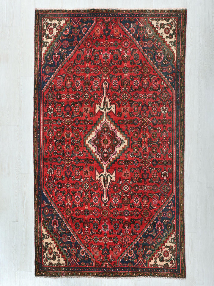 a red rug with a diamond shaped design