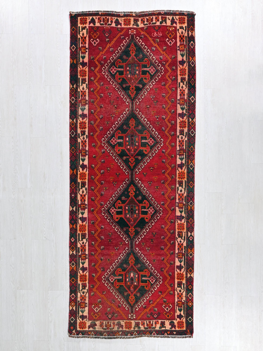 a red and black rug hanging on a wall