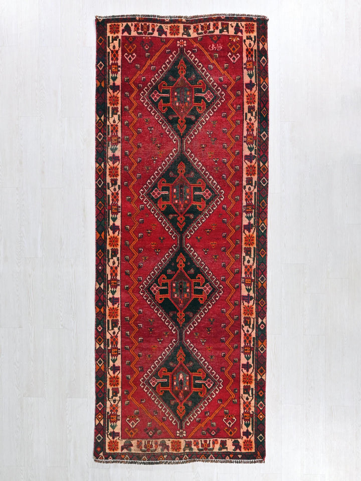a red and black rug hanging on a wall
