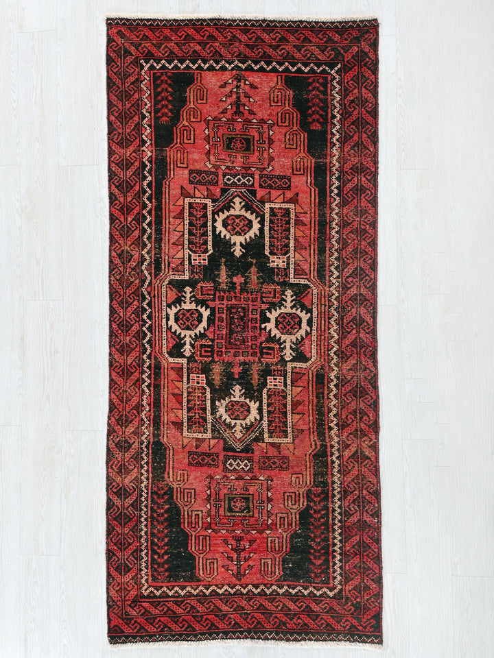 a red and black rug hanging on a wall