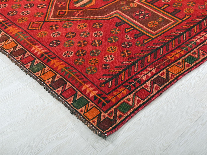 a red oriental rug on a white floor
