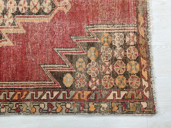 a red rug on a white wooden floor