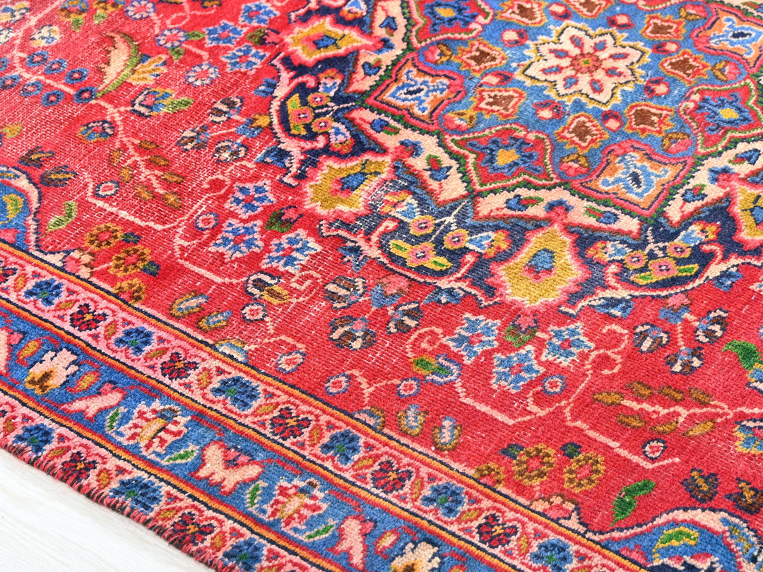 a red oriental rug with a blue border