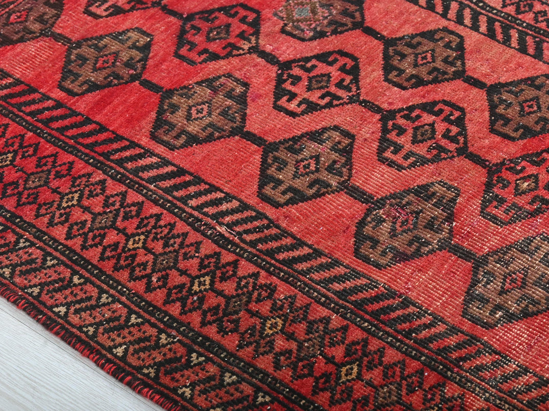 a close up of a red rug on a white surface