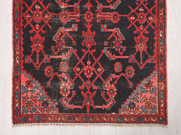 a red and black oriental rug on a white floor
