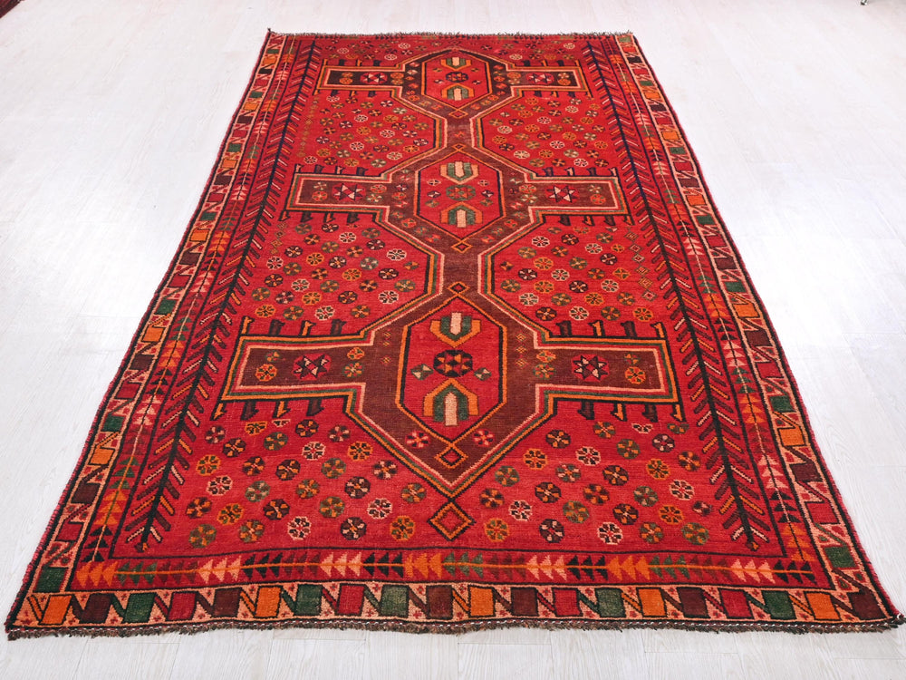 a red oriental rug on a white floor