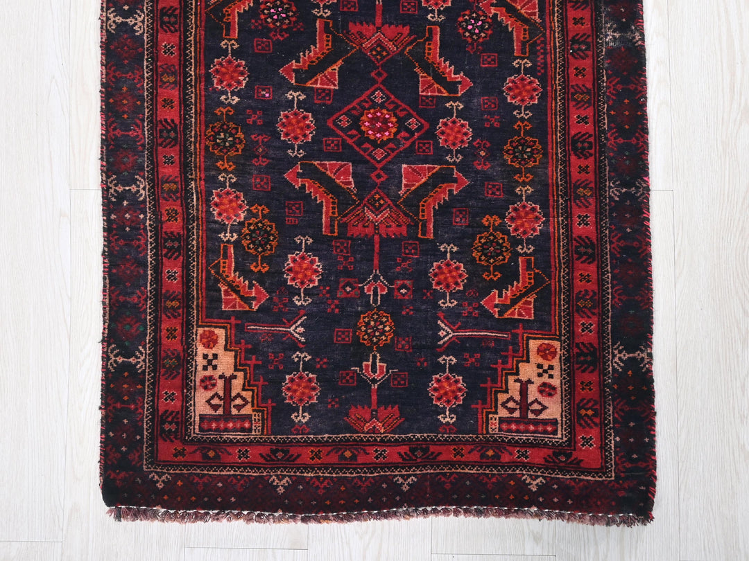 a red and black oriental rug on a white floor