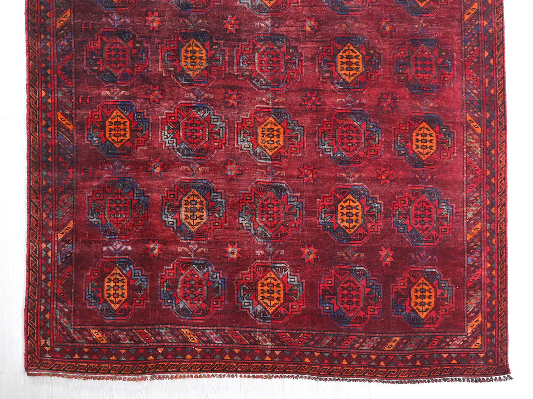 a red rug with a design on the middle of it
